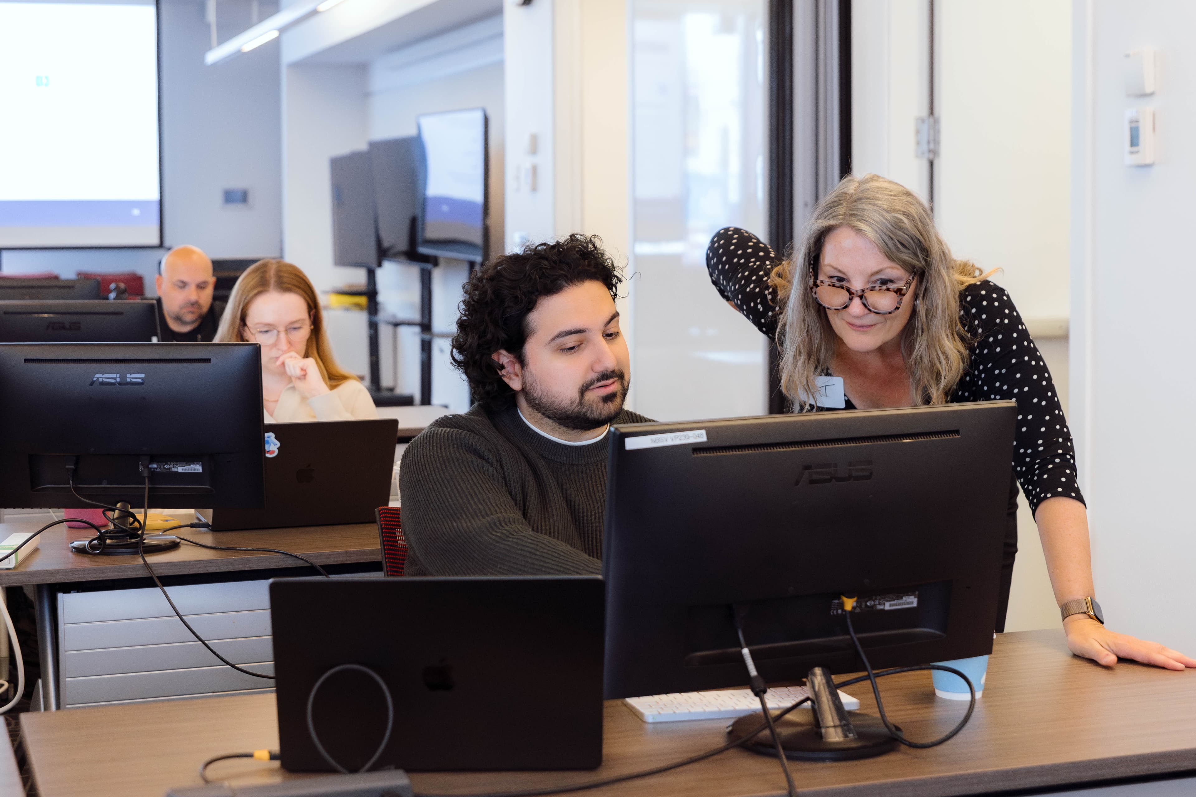 Instructor helping a workshop participant at their computer